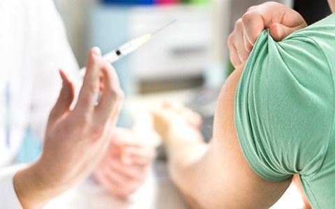 Doctor giving patient a shot in the arm.