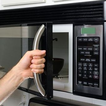 Hand holding a microwave handle