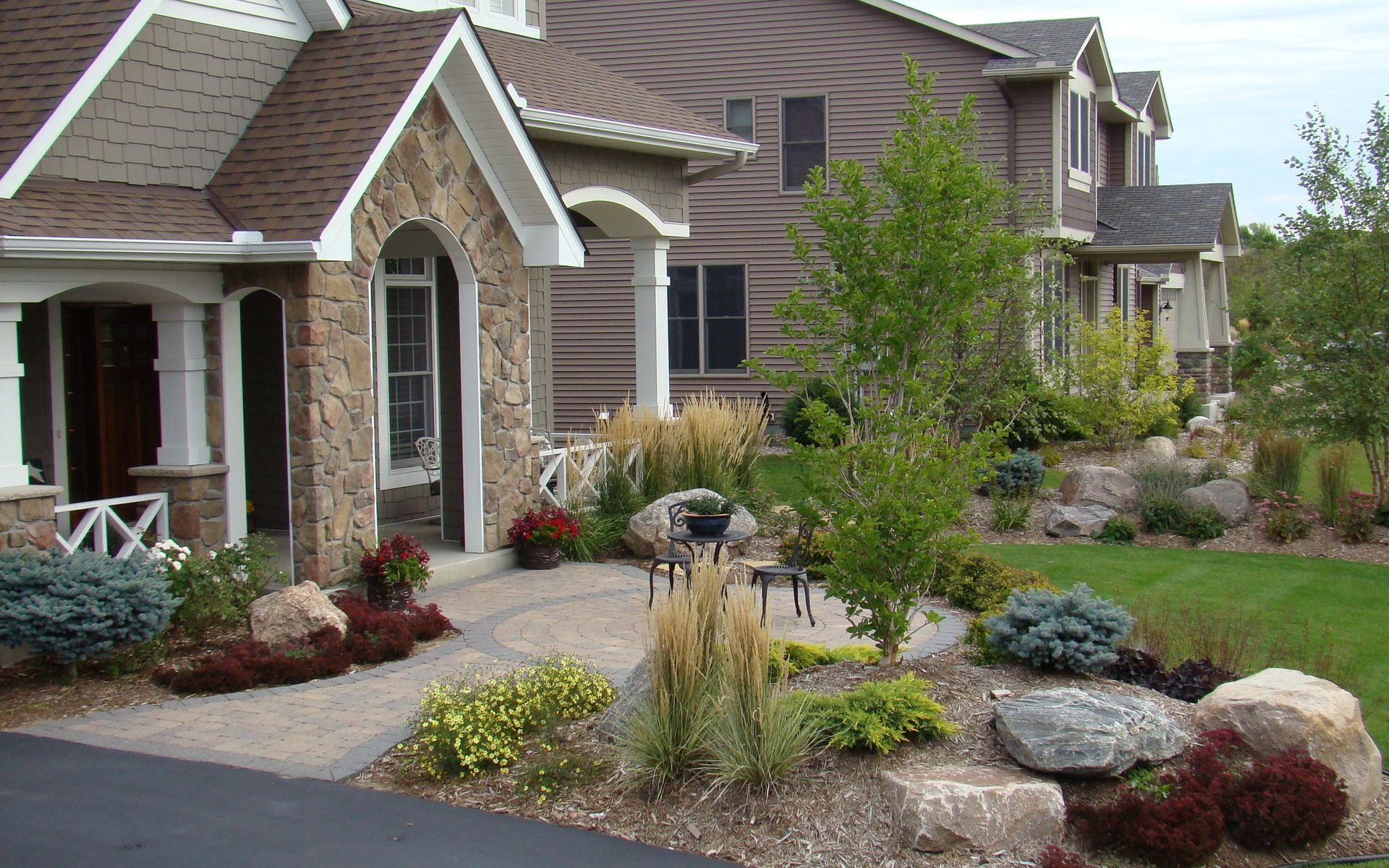 Stone and wood facade houses with landscaping, pathway.