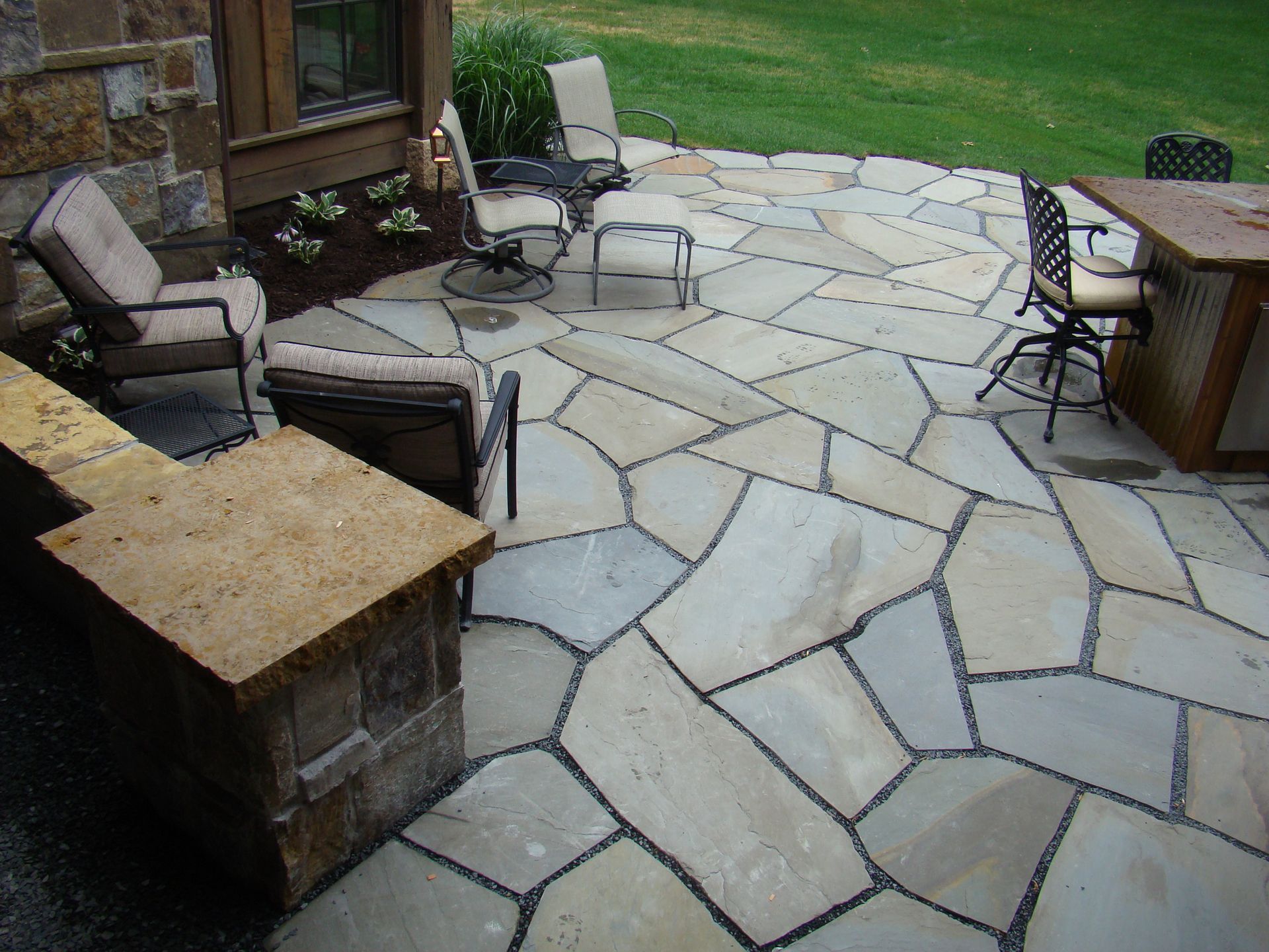 Stone patio with outdoor seating and a built-in bar.