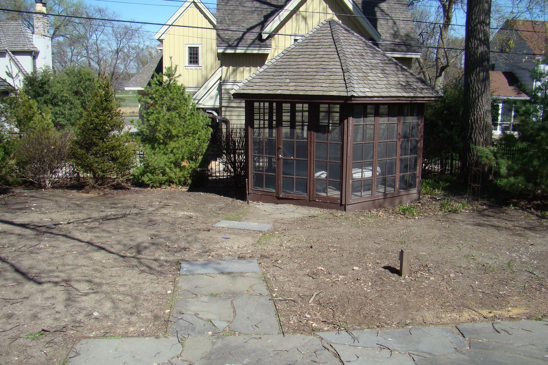 Gazebo in backyard with a pathway, house in background.
