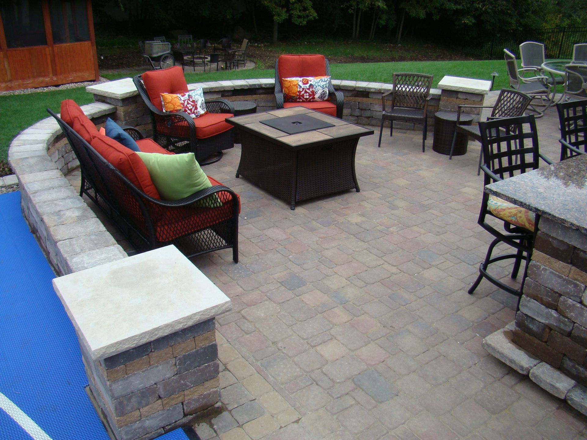 Patio with outdoor furniture, fire pit, and stone retaining walls.