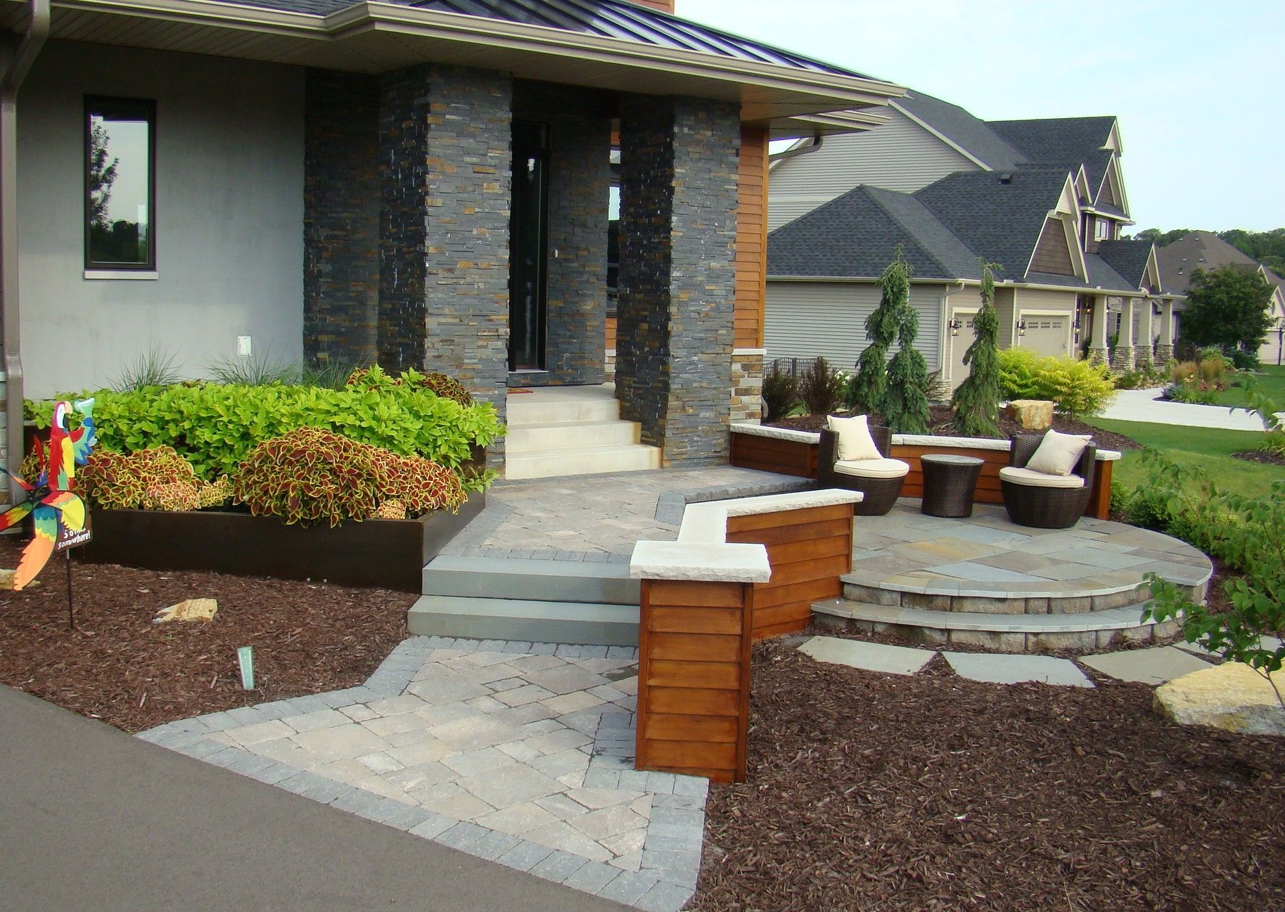 Stone entryway with steps leading to a seating area with chairs and a low wooden bench.