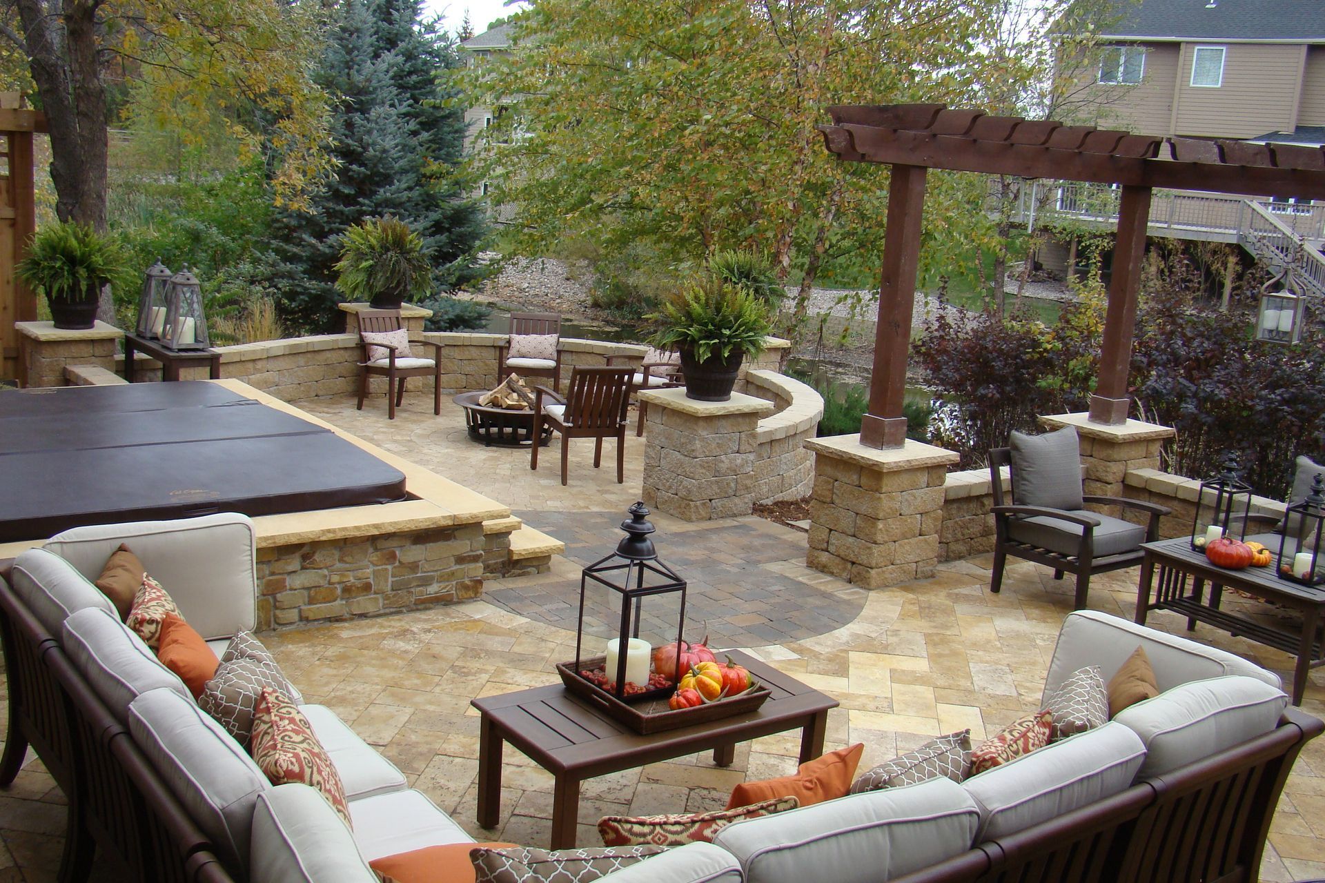 Outdoor patio with stone walls, seating areas, and a hot tub.