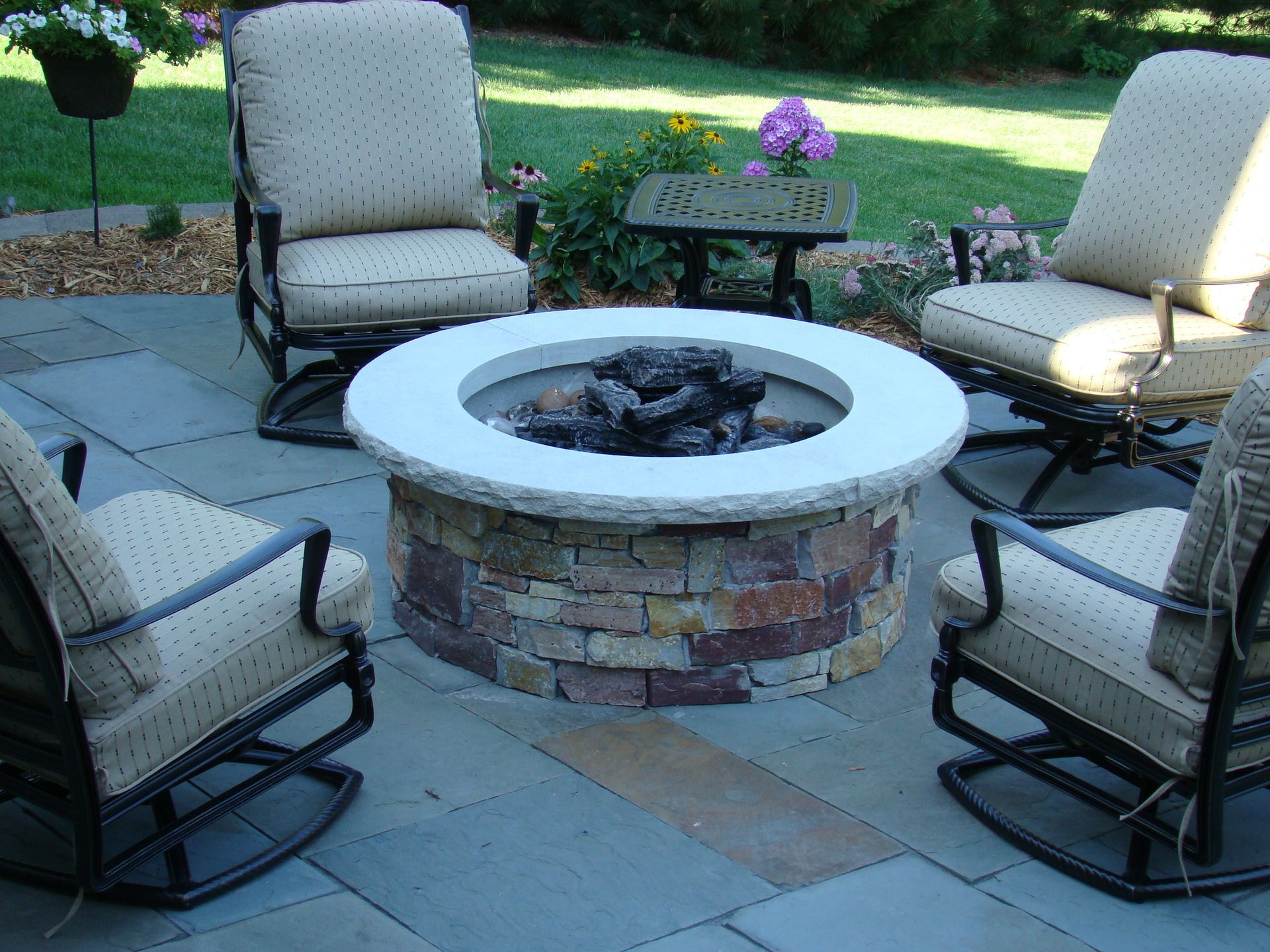 Stone fire pit with seating on a patio.