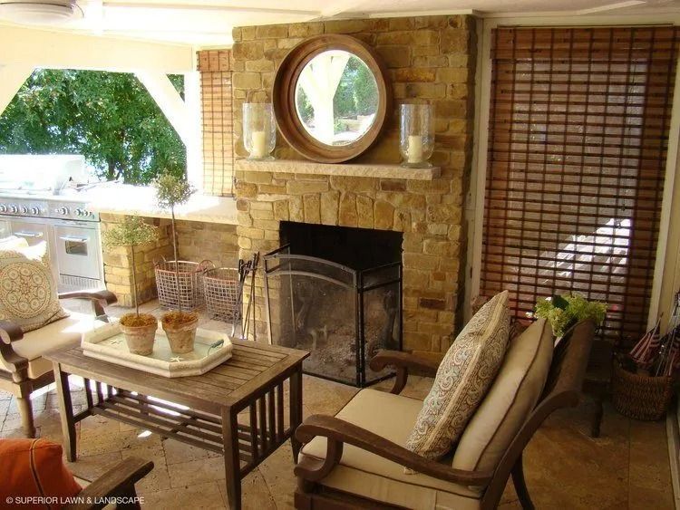 Cozy outdoor living area with stone fireplace, seating, and decorative accents.