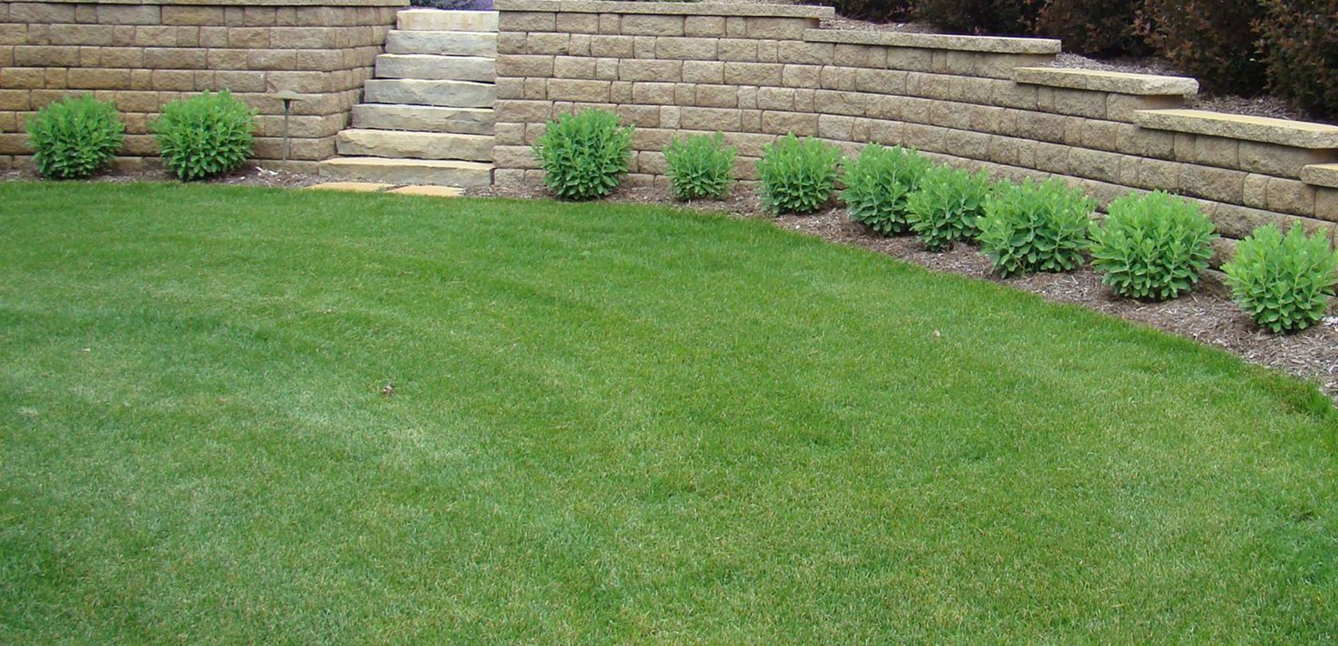 Lush backyard with a multi-level house, gazebo, garden, and a person tending to the plants.