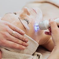 A woman is getting a facial treatment at a spa.