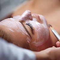 A woman is getting a facial treatment at a spa.