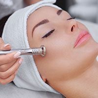 A woman is getting a facial treatment at a beauty salon.