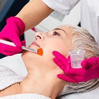 A woman is getting a facial treatment at a beauty salon.