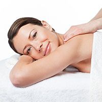 A woman is laying on a massage table getting a massage.