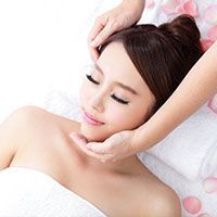 A woman is getting a head massage at a spa.