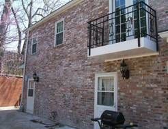 Brick building with a small balcony, door, and grill.