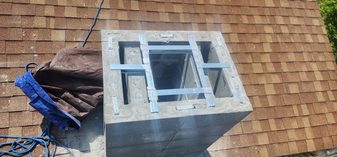 Chimney with metal bars on rooftop. Brown shingles, tarp, blue rope. Sunny day.