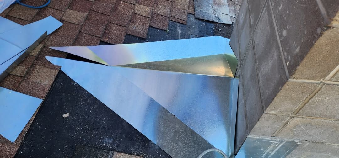 Metal flashing being installed on a roof near a wall.