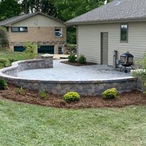 A house with a patio and a fire pit in front of it.