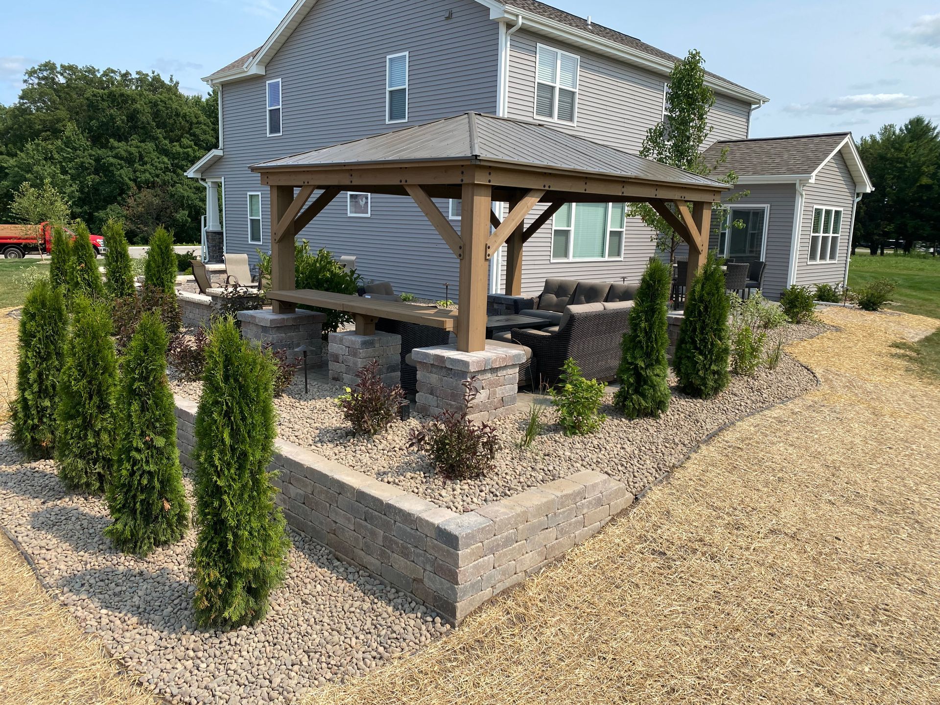 A large house with a wooden gazebo in front of it.