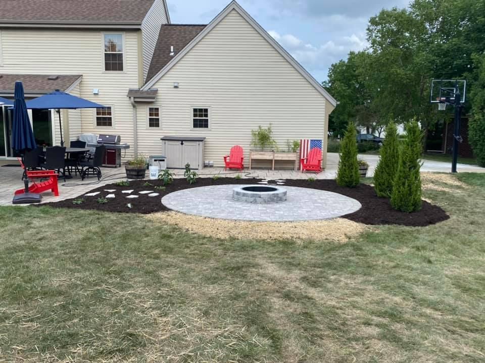 There is a fire pit in the middle of the backyard.