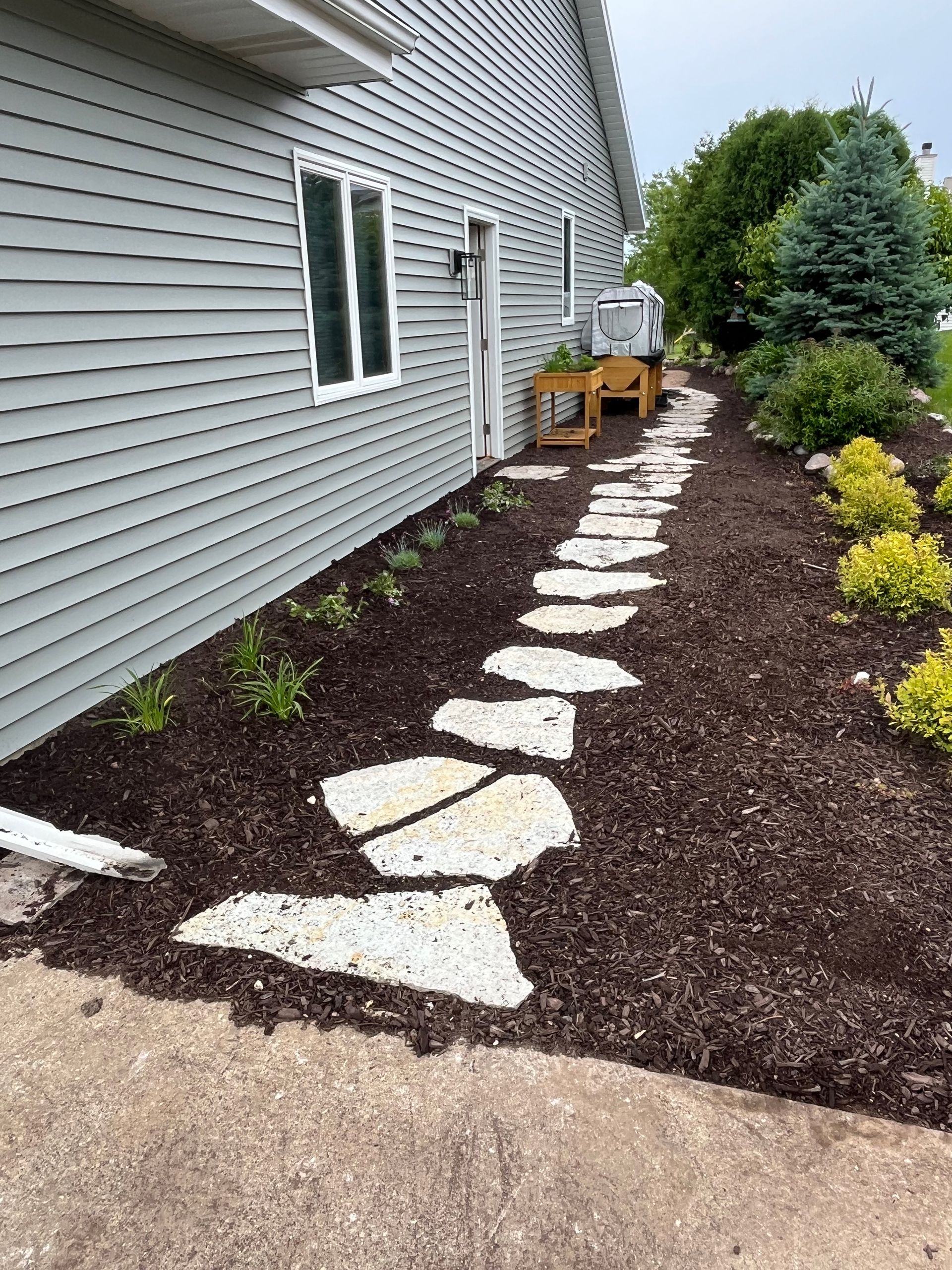 A stone walkway leading to the front door of a house.