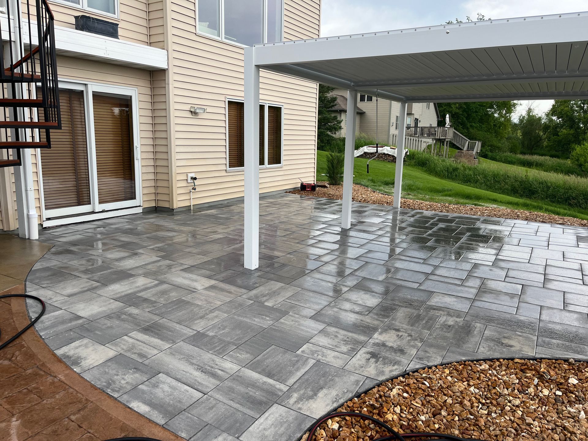 A patio with a canopy and stairs in front of a house.