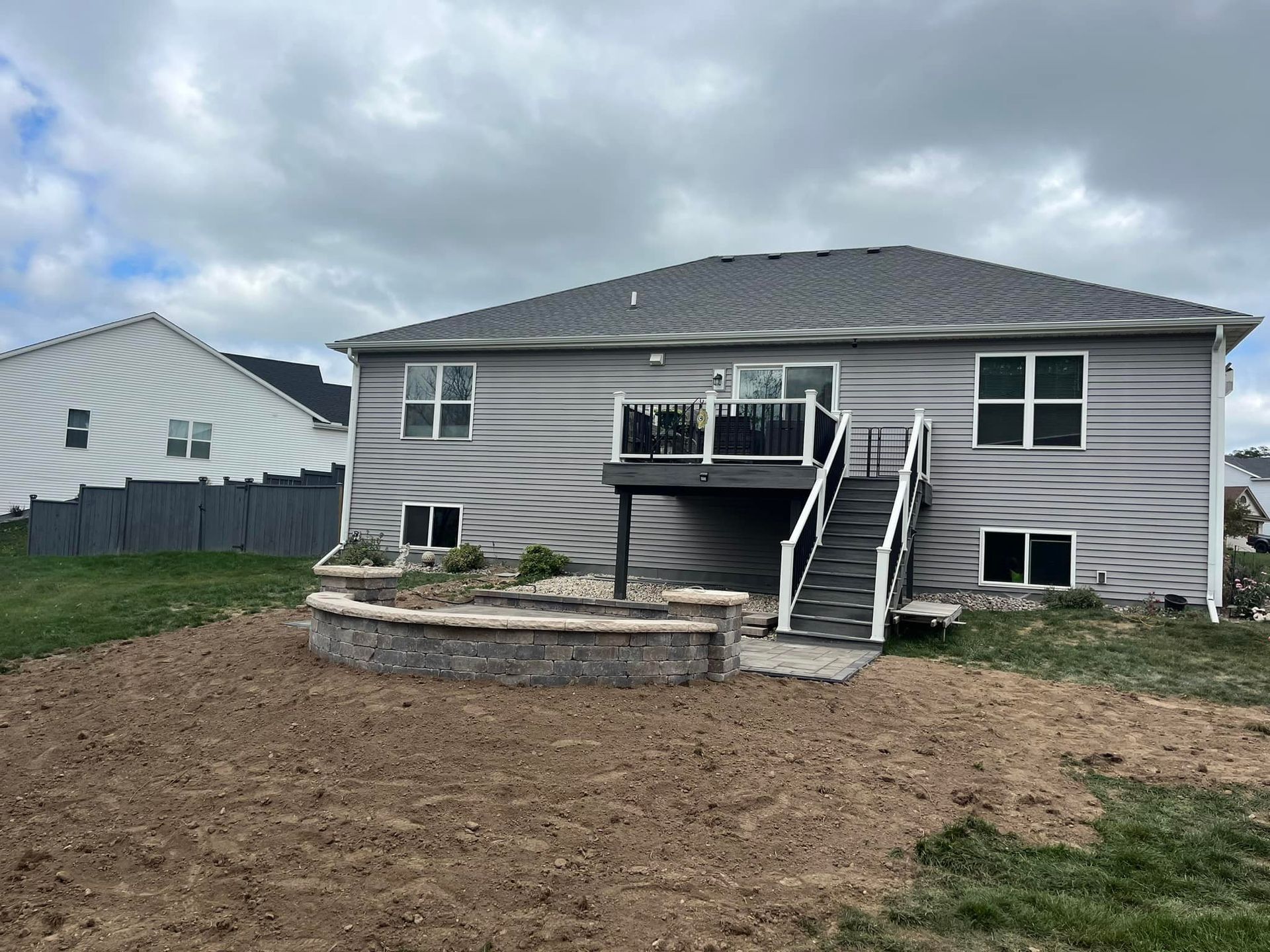 The back of a house with a large deck and stairs.