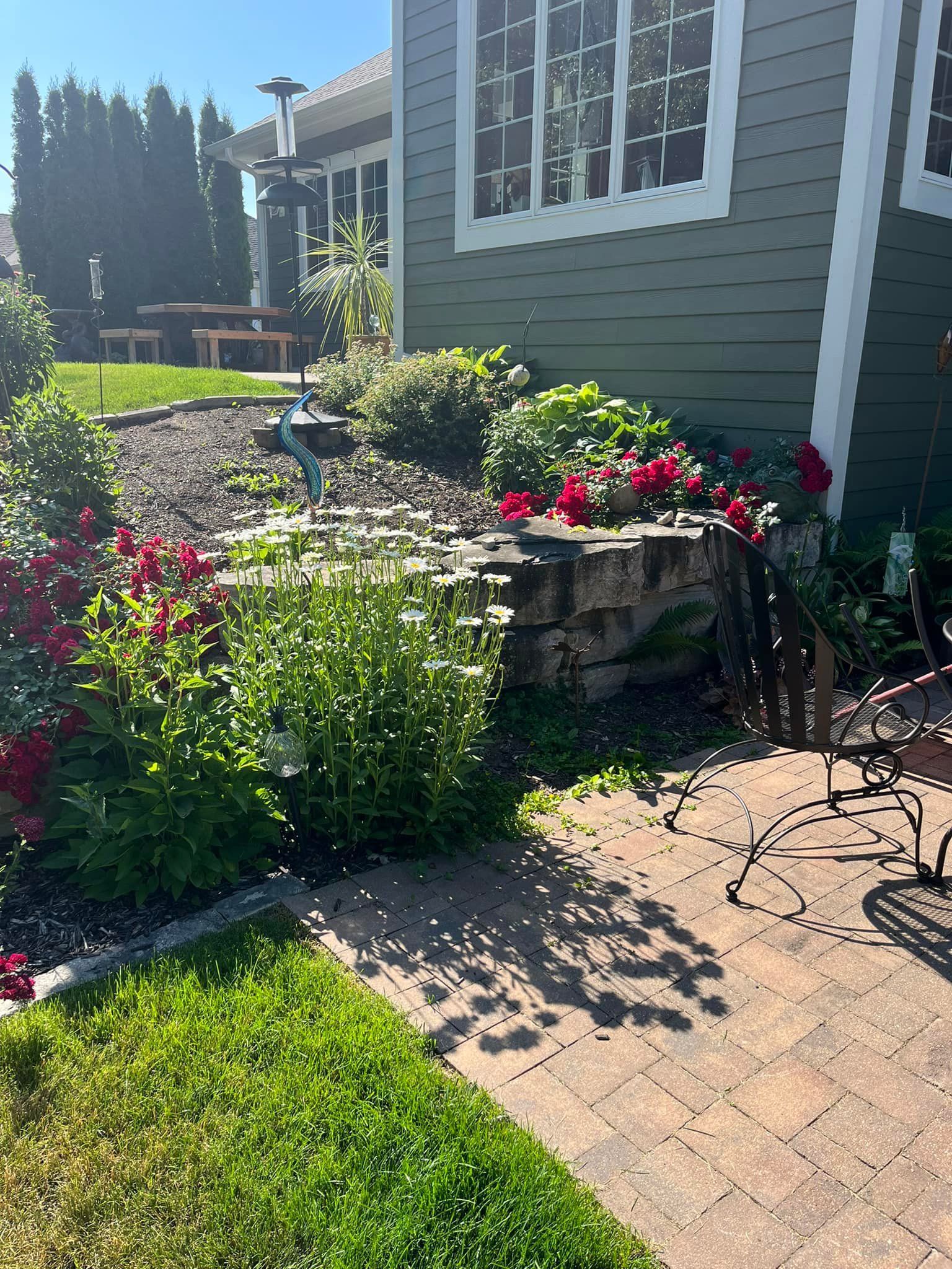 A house with a patio and flowers in front of it.