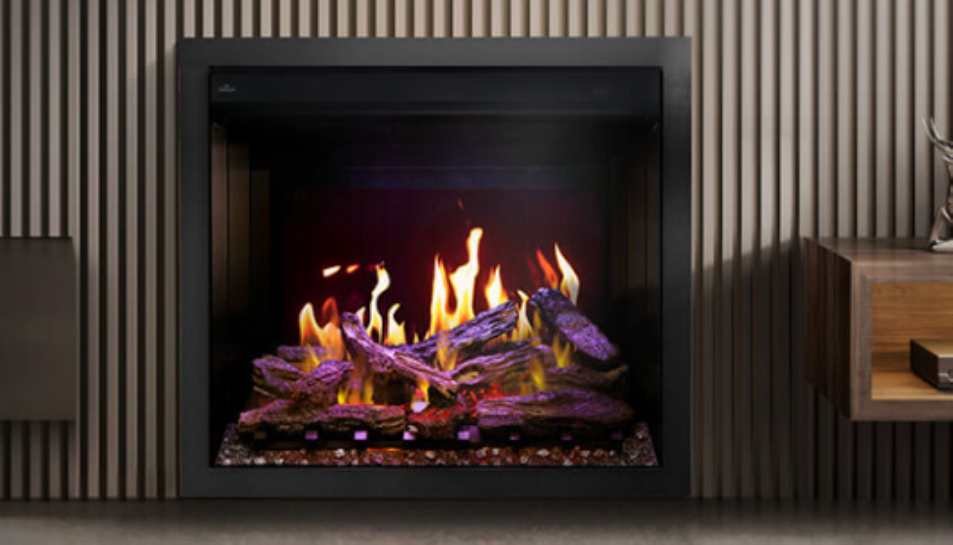 Modern black fireplace with bright orange flames and purple glass embers against a striped wall