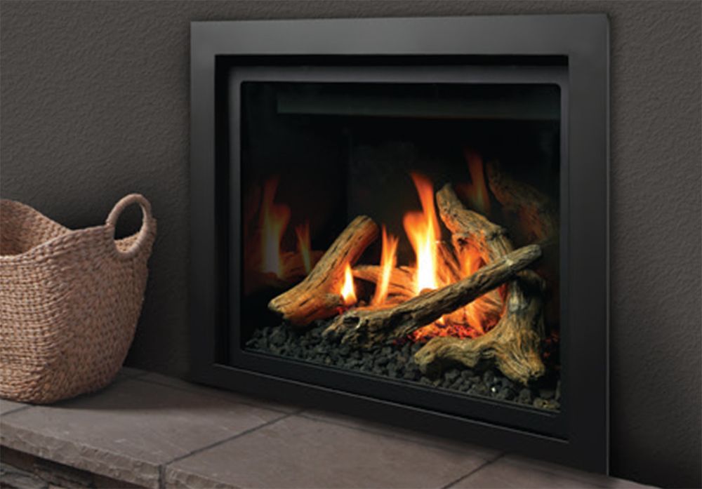 Modern black fireplace with burning logs next to a woven basket on a stone hearth.