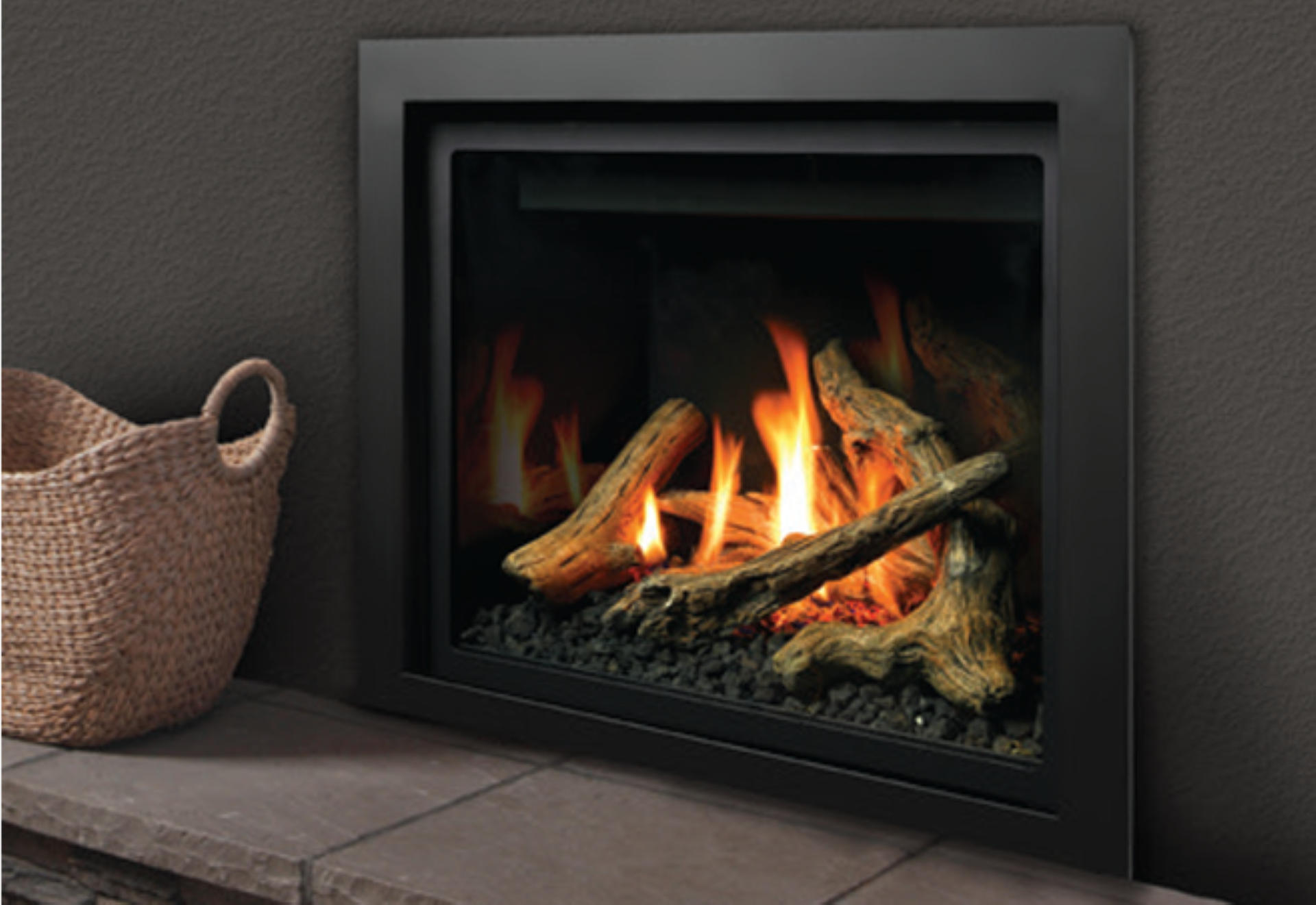 Modern black fireplace with burning logs beside a woven basket on a hearth