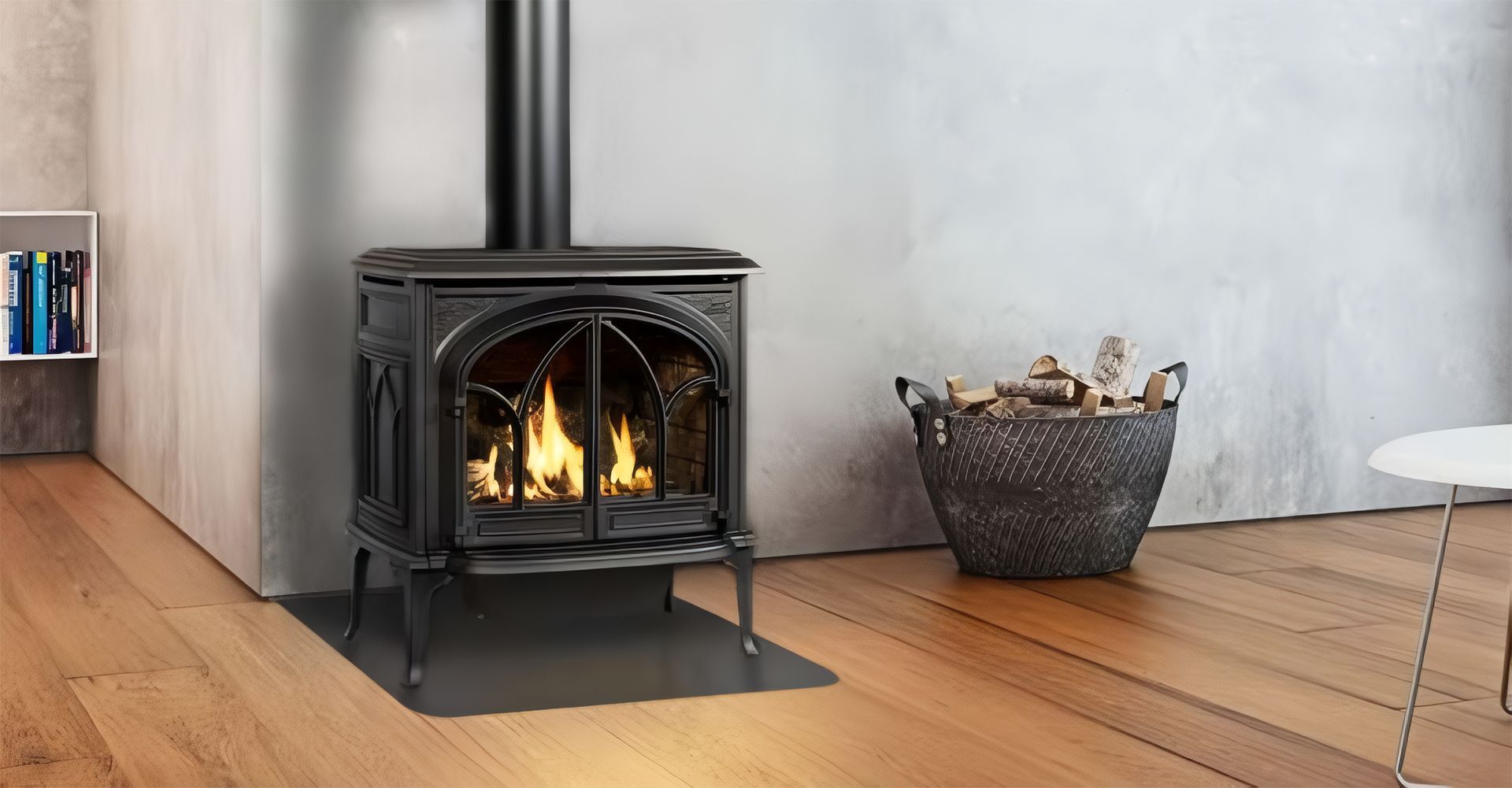 Black wood-burning stove with flames on a wooden floor beside a woven basket