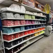 A store shelf filled with lots of colorful shirts