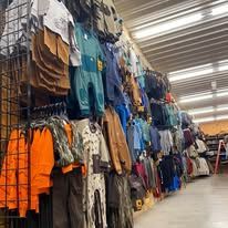 A row of clothes hanging on a wall in a store