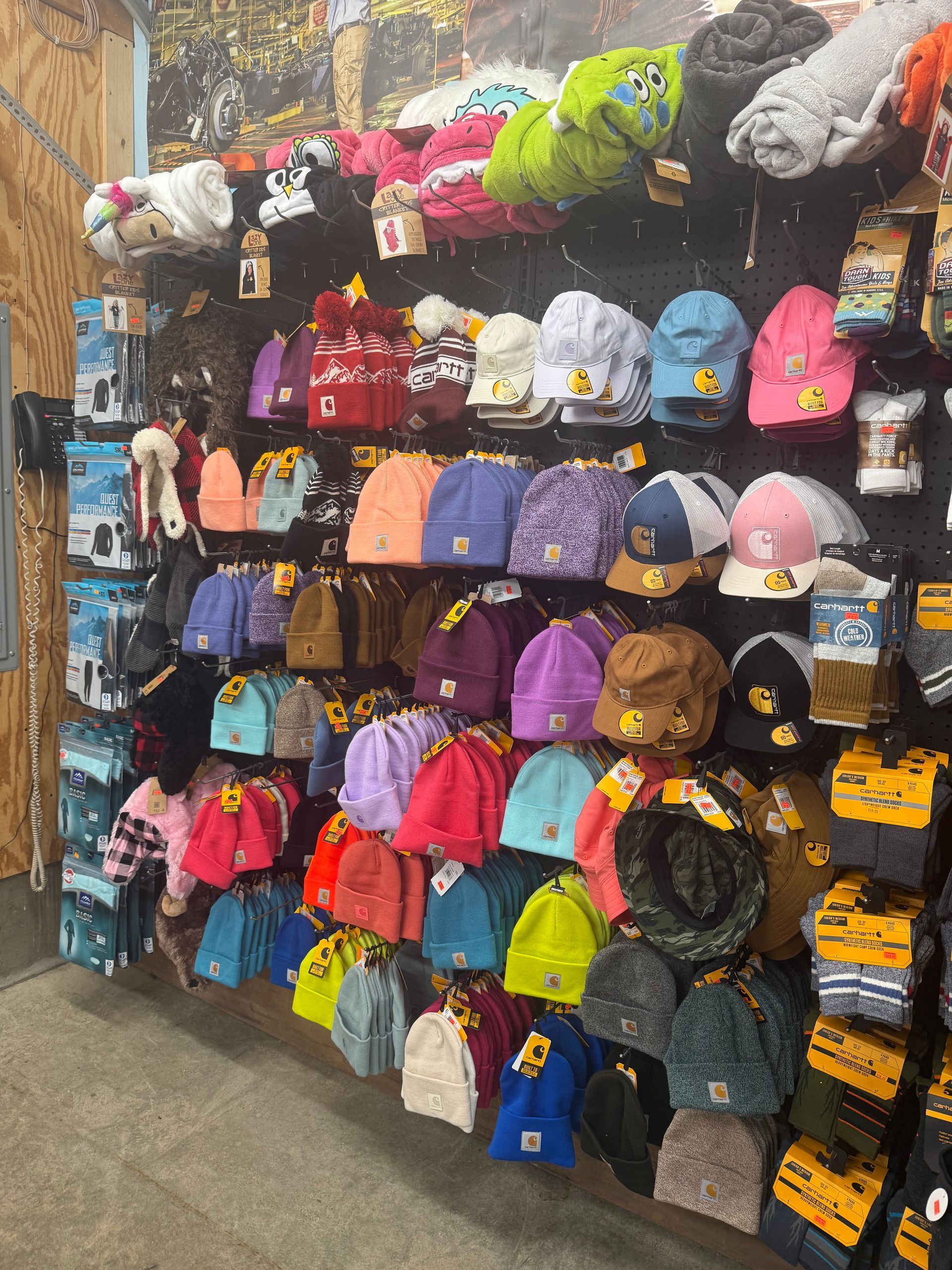 A wall filled with lots of hats and blankets in a store