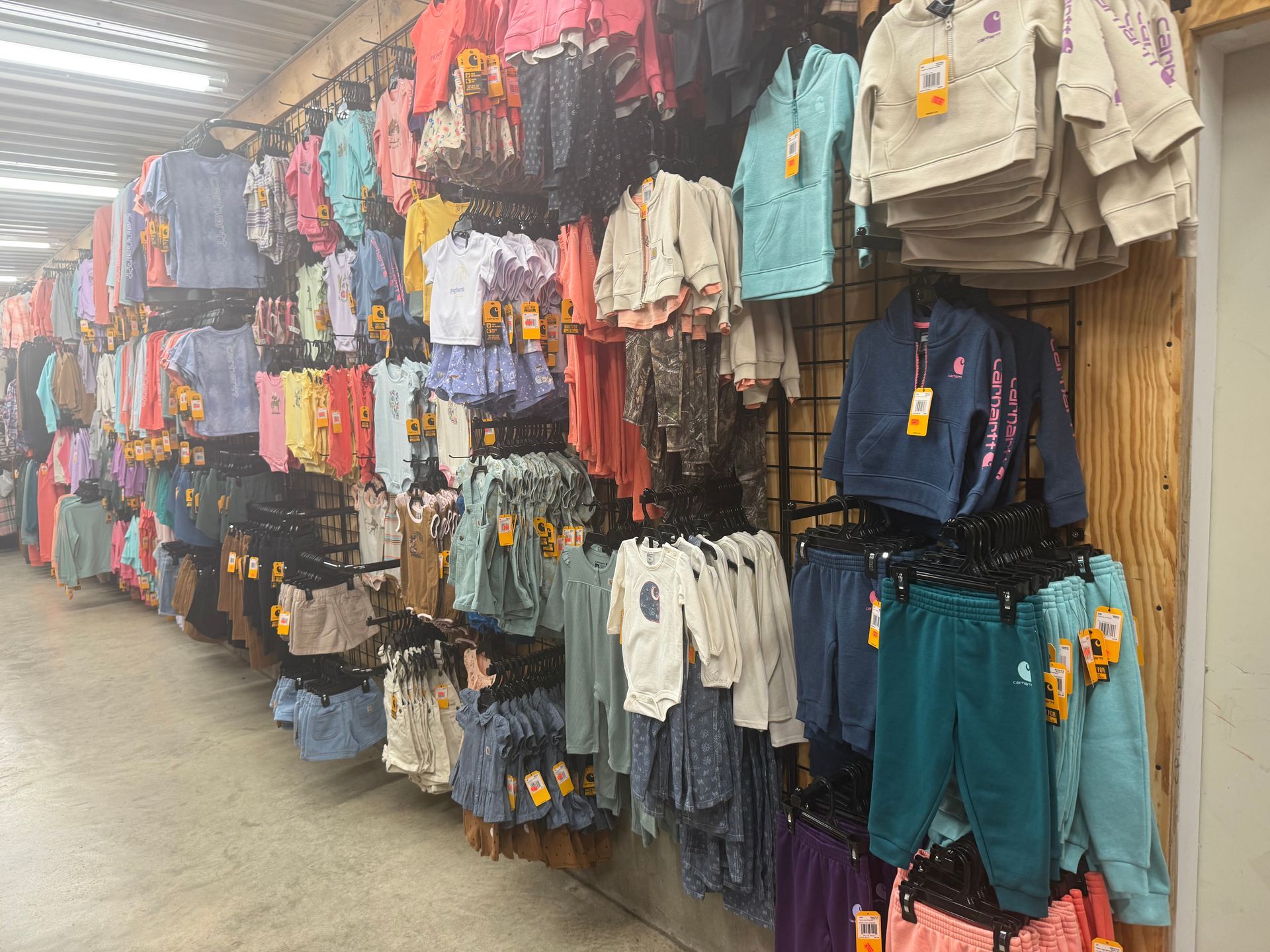 A row of clothes hanging on a wall in a store
