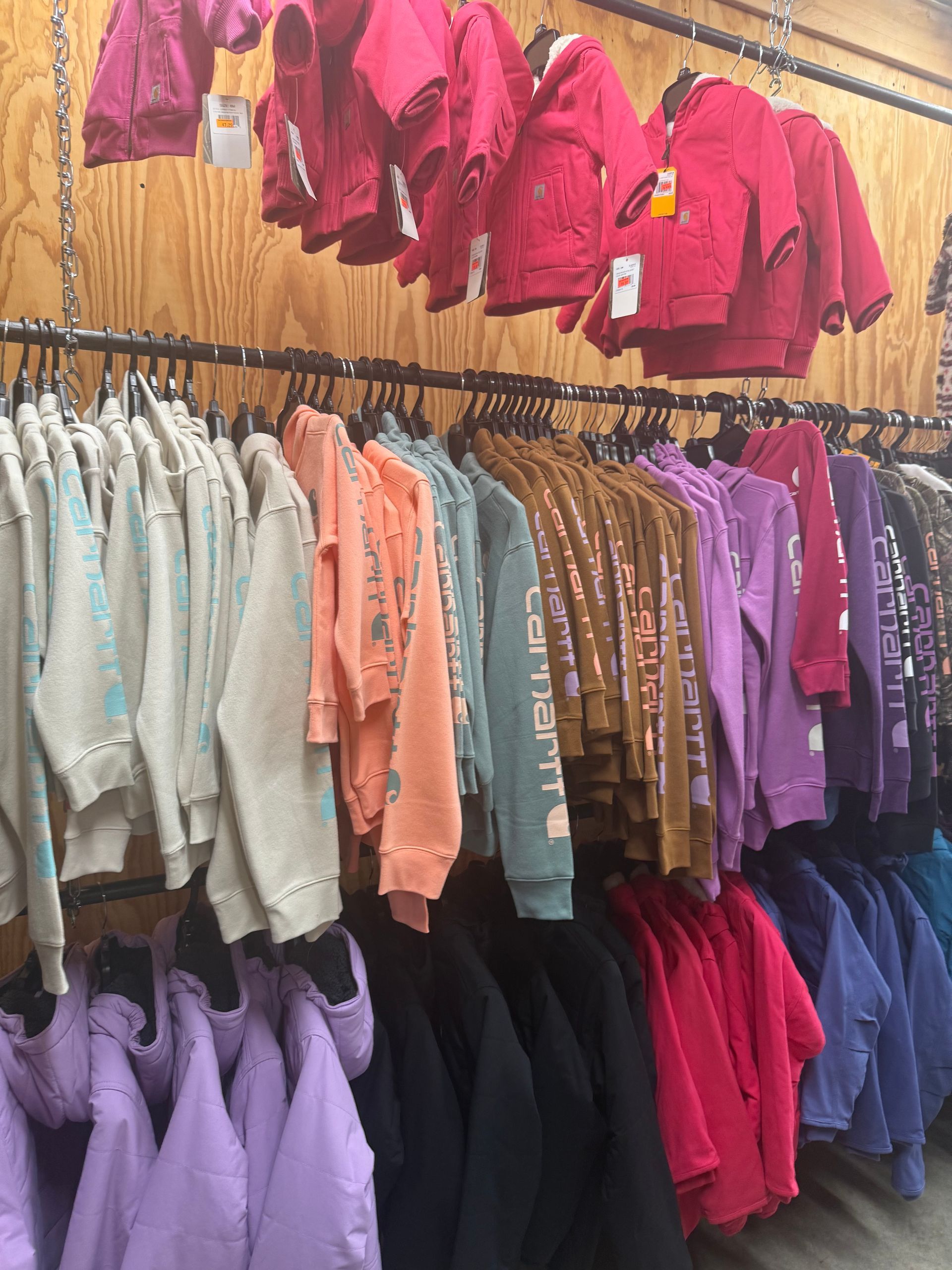 A bunch of jackets are hanging on a rack in a store