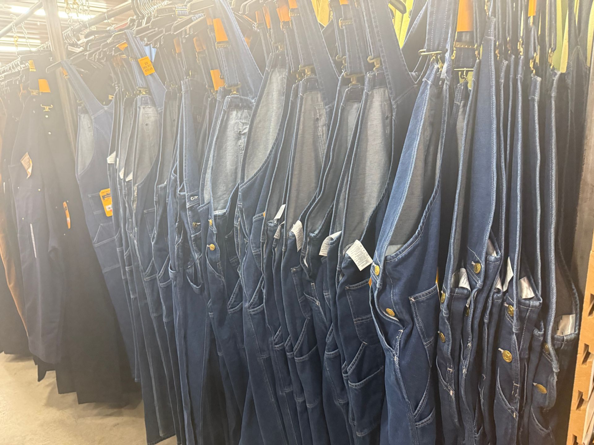 A row of overalls hanging on a rack in a store