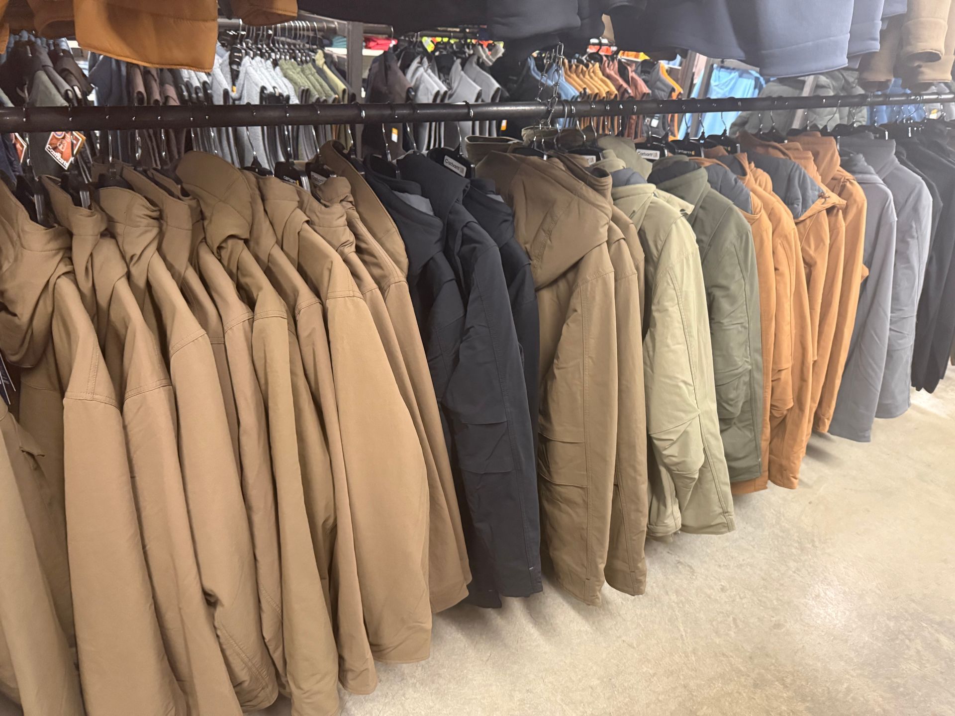 A row of jackets are hanging on a rack in a store