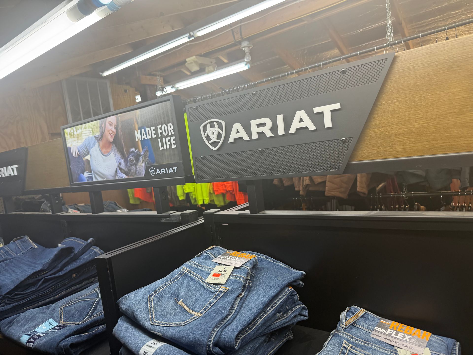 A stack of jeans is sitting on a shelf in a store