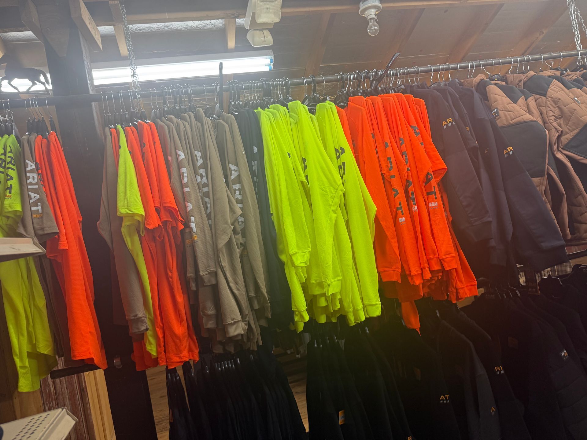 A bunch of shirts are hanging on a rack in a store.