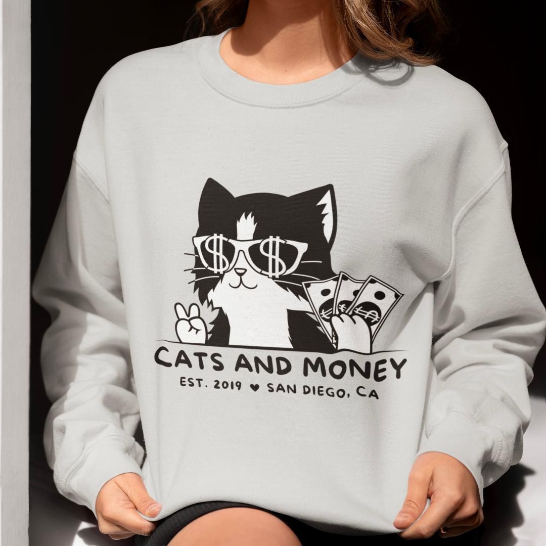 A woman is wearing a sweatshirt that says cats and money