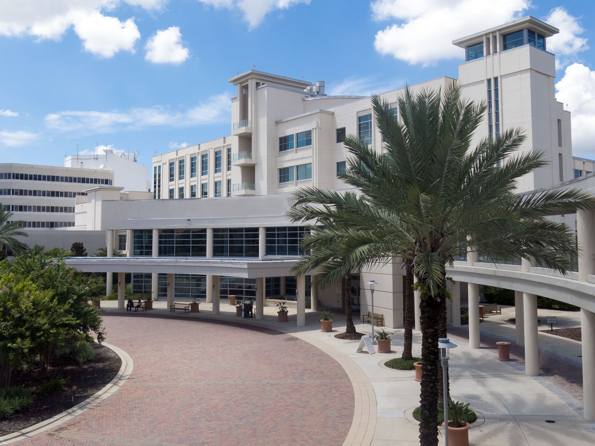 A large white building with palm trees in front of it