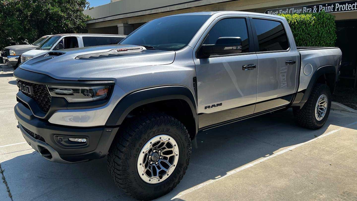 Silver Ram TRX truck parked in front of a building.