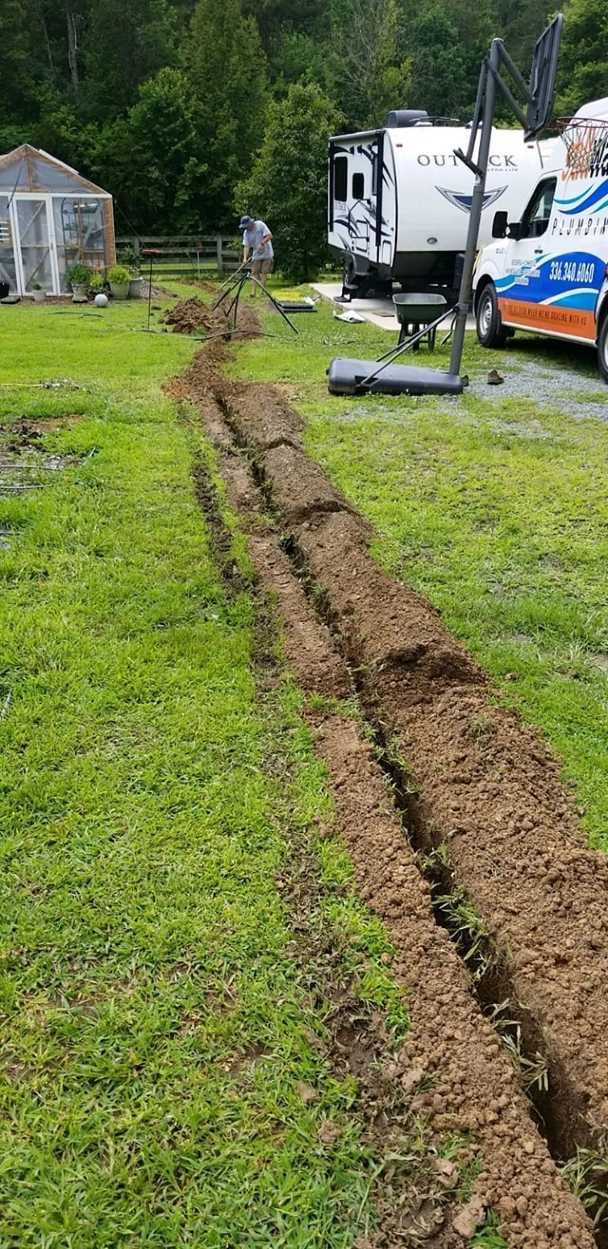A truck is parked in a grassy field next to a rv.