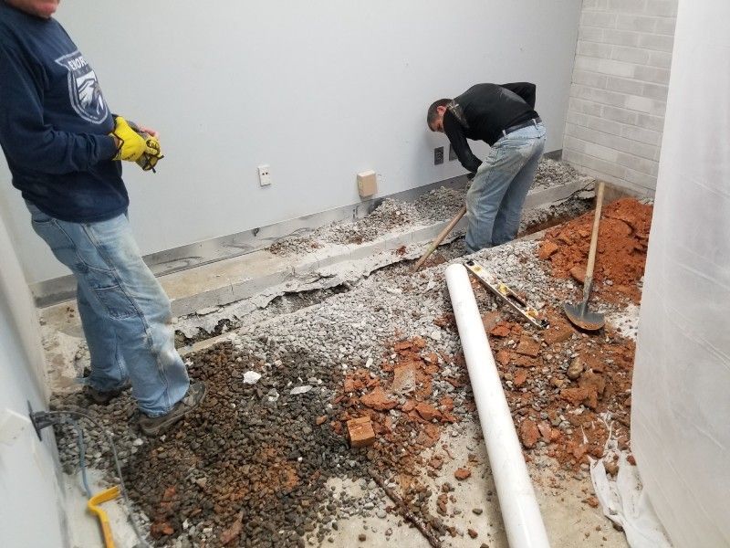 A man wearing a sweatshirt that says ' army ' on it is working on the floor