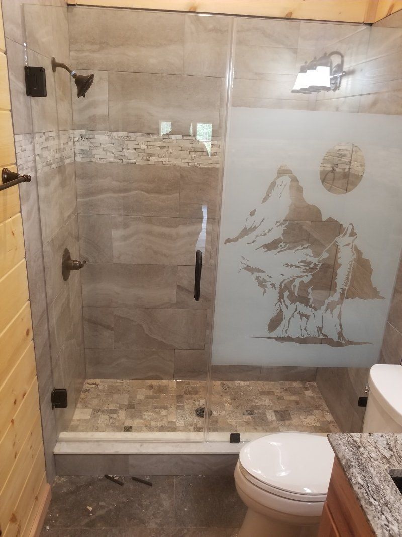 A bathroom with a walk in shower and a toilet.