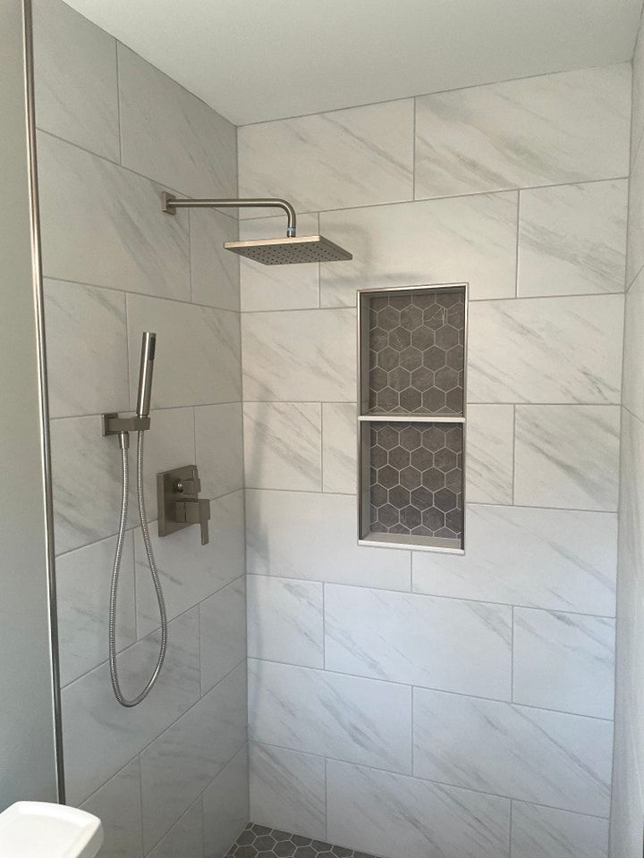 A bathroom with a walk in shower and a shower head.