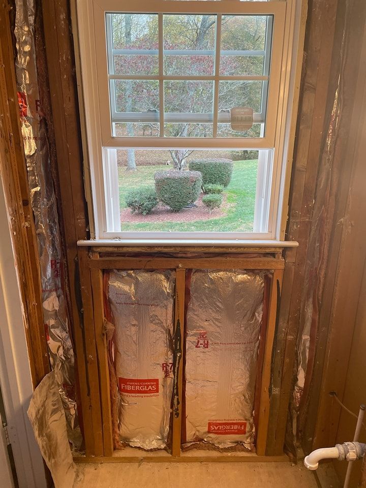 A window is being built into a wall in a bathroom.