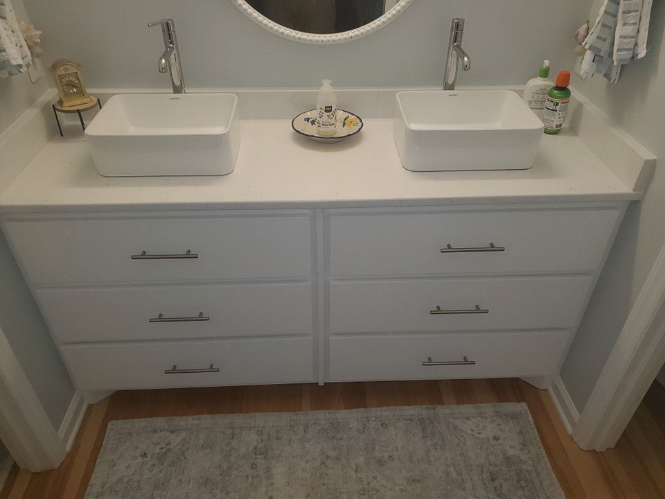 A bathroom vanity with two sinks and a mirror
