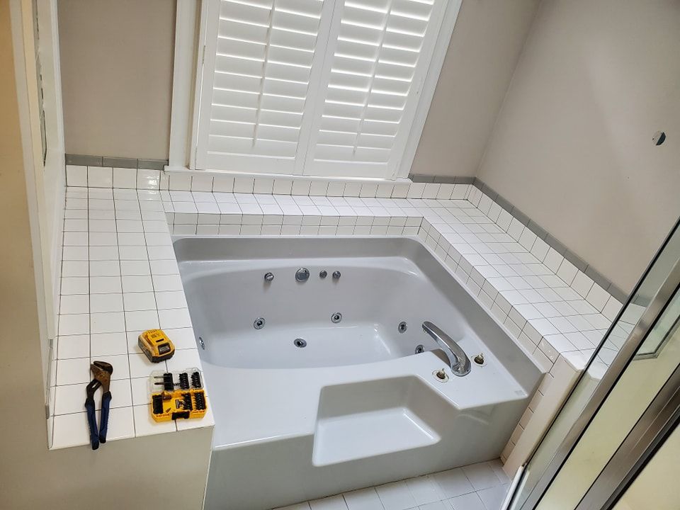 A bathroom with a jacuzzi tub and a window
